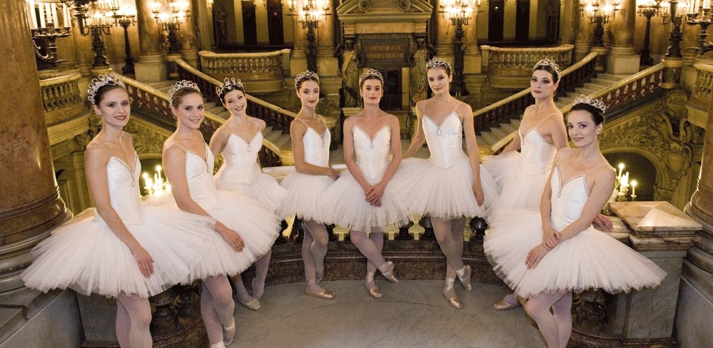 Photo de 8 Etoiles de l'Opra de Paris de 2013. Les danseuses sont en tutu blanc, pointes aux pieds. Elles se trouvent sur le balcon  l'tage dans l'entre de L'Opra