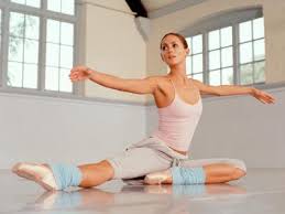 Danseuse effectuant un port de bras au sol. Etirement et assouplissement des jambes